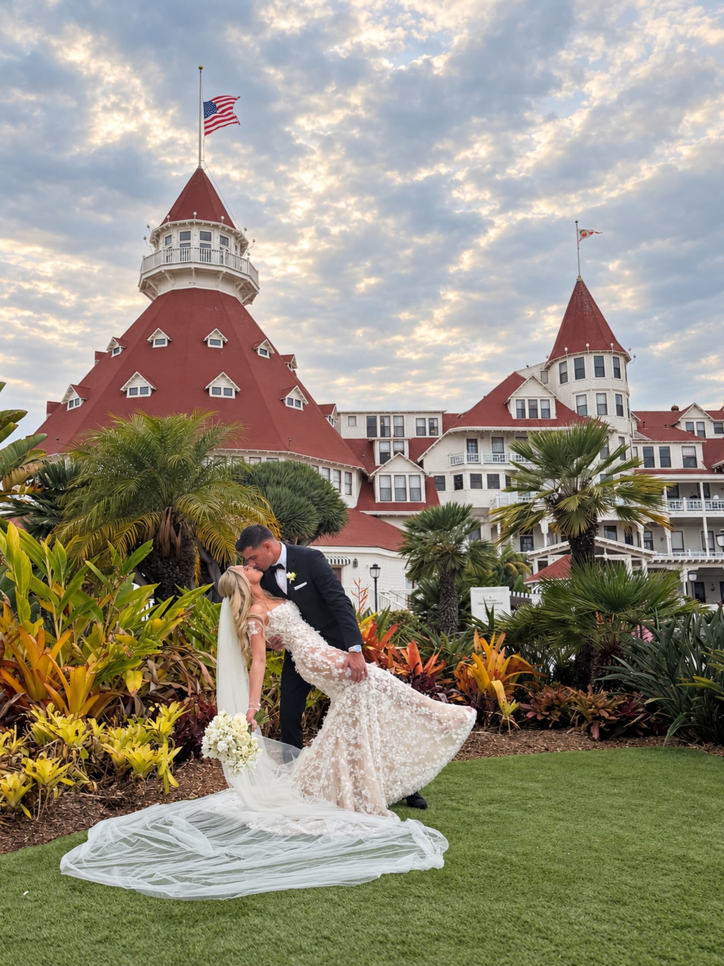 Newlyweds sharing a dip kiss in front of Hotel del Coronado